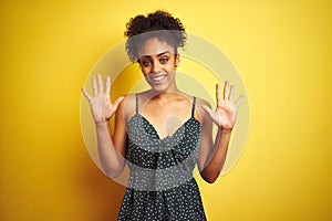 African american woman wearing summer casual green dress over isolated yellow background showing and pointing up with fingers