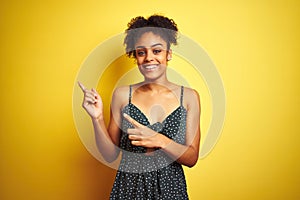 African american woman wearing summer casual green dress over isolated yellow background smiling and looking at the camera