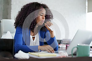 African American Woman Working At Home Coughing And Sneezing photo