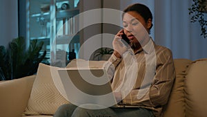 African American woman working from home multitasking female businesswoman talk mobile phone in evening room make online