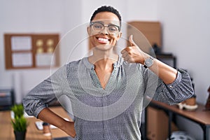 African american woman working at the office wearing glasses doing happy thumbs up gesture with hand