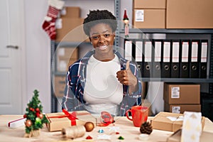 African american woman working at small business doing christmas decoration doing happy thumbs up gesture with hand