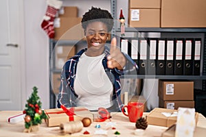 African american woman working at small business doing christmas decoration smiling friendly offering handshake as greeting and