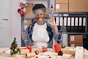 African american woman working at small business doing christmas decoration smiling positive doing ok sign with hand and fingers