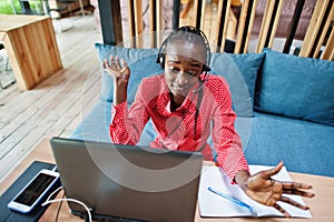 African american woman works in a call center operator and customer service agent wearing microphone headsets working on laptop