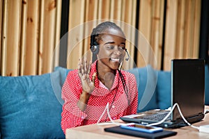 African american woman works in a call center operator and customer service agent wearing microphone headsets working on laptop