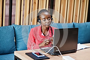 African american woman works in a call center operator and customer service agent wearing microphone headsets working on laptop