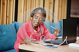 African american woman works in a call center operator and customer service agent wearing microphone headsets working on laptop