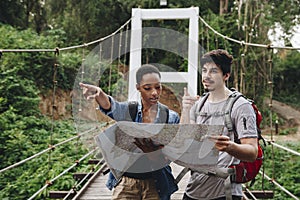 African American woman and a Caucasian man looking at a map together travel and teamwork concept