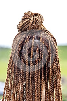 African American Women With Hair Braided Into A Cornrow Hairstyle Using Synthetic Hair Extensions. Texture of thin brown African