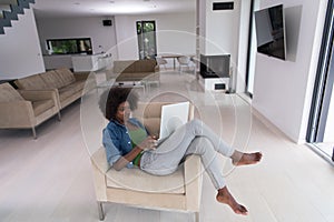 African American women at home in the chair using a laptop