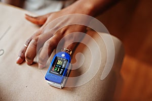 African american women with pulse oximeter on hand measuring oxygen saturation level