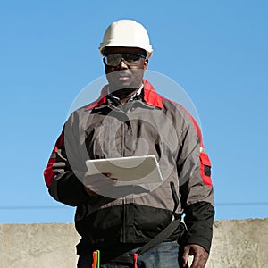 African american worker holds in hands tablet computer and looks at camera