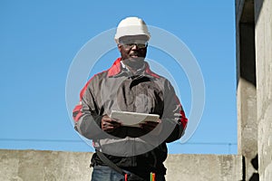 African american worker holds in hands tablet computer and looks at camera