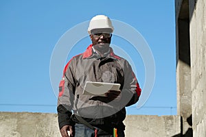 African american worker holds in hands tablet computer and looks at camera