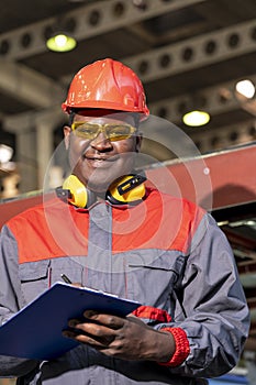 African American Worker In Personal Protective Equipment Holding Clipboard And Looking At Camera