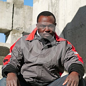 African american worker sits at construction area and looks at camera