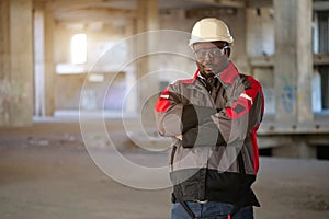 African american worker stands at construction area and looks at camera