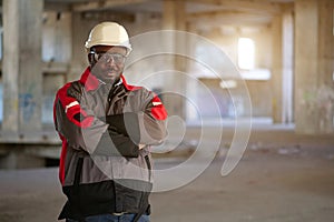 African american worker stands at construction area and looks at camera