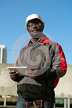 African american worker with tablet computer stands at construction site