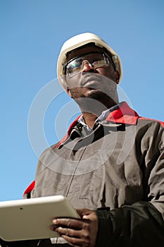 African american worker with tablet computer stands at construction site