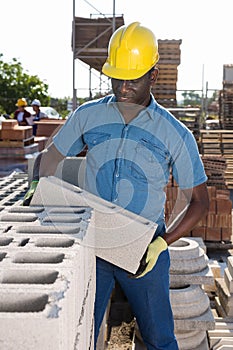 African american worker warehouse lays bricks