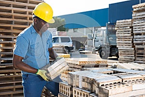 African american worker warehouse lays bricks