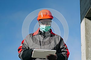 African american workman holds in hands white tablet computer