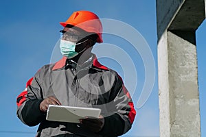 African american workman holds in hands white tablet computer