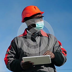 African american workman holds in hands white tablet computer