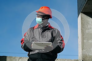 African american workman holds in hands white tablet computer