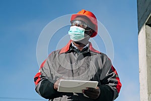 African american workman holds in hands white tablet computer