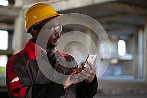 African american workman with smartphone at construction site