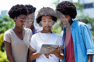 African american young adults watching movie with digital tablet