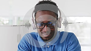 African-American young man listen to music in headphones with equalizer hologram