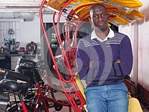 African-American young man rickshaw cycle driver standing