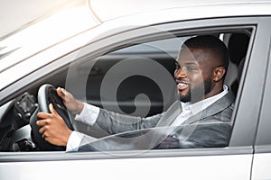 African american young man in suit driving car