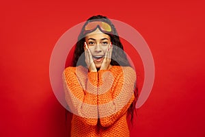 African-american young woman`s portrait in ski mask on red background