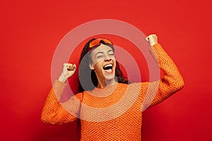 African-american young woman`s portrait in ski mask on red background