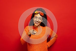 African-american young woman`s portrait in ski mask on red background