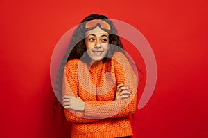 African-american young woman`s portrait in ski mask on red background