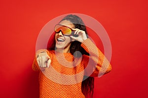 African-american young woman`s portrait in ski mask on red background