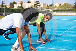 African athletes in starting position on an athletics track