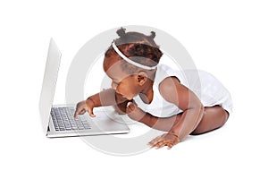 African, baby girl in studio with laptop in portrait, curious or play with computer. Female child on backdrop with