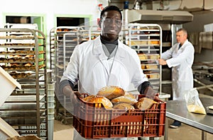 African baker carrying box with baked bread