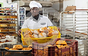 African baker carrying box with baked bread