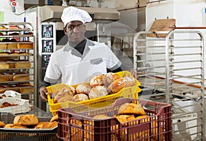 African baker carrying bread in box