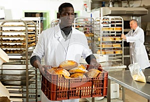 African baker carrying bread in box