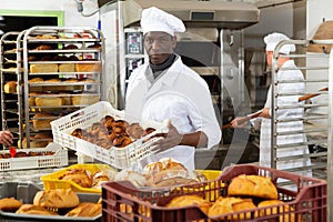 African baker carrying bread in box