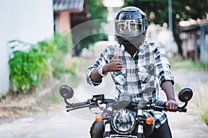 African biker in the helmet and glasses driving a motorcycle rides photo